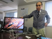 オフィスにて裸眼3Dモニターと手術の裸眼3D映像について説明する、FASE・中村社長